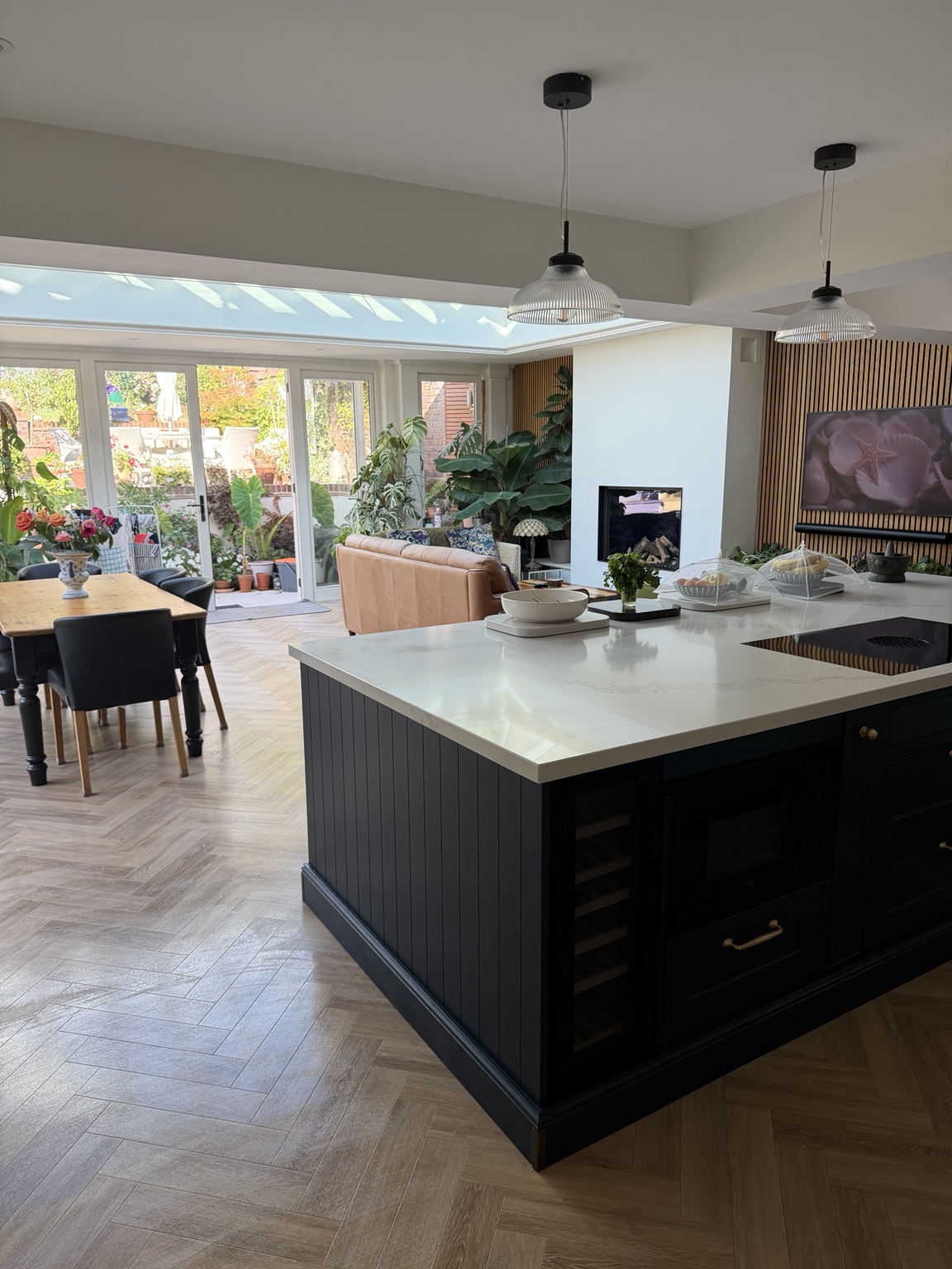 Open-plan kitchen and living space with a white island and garden doors